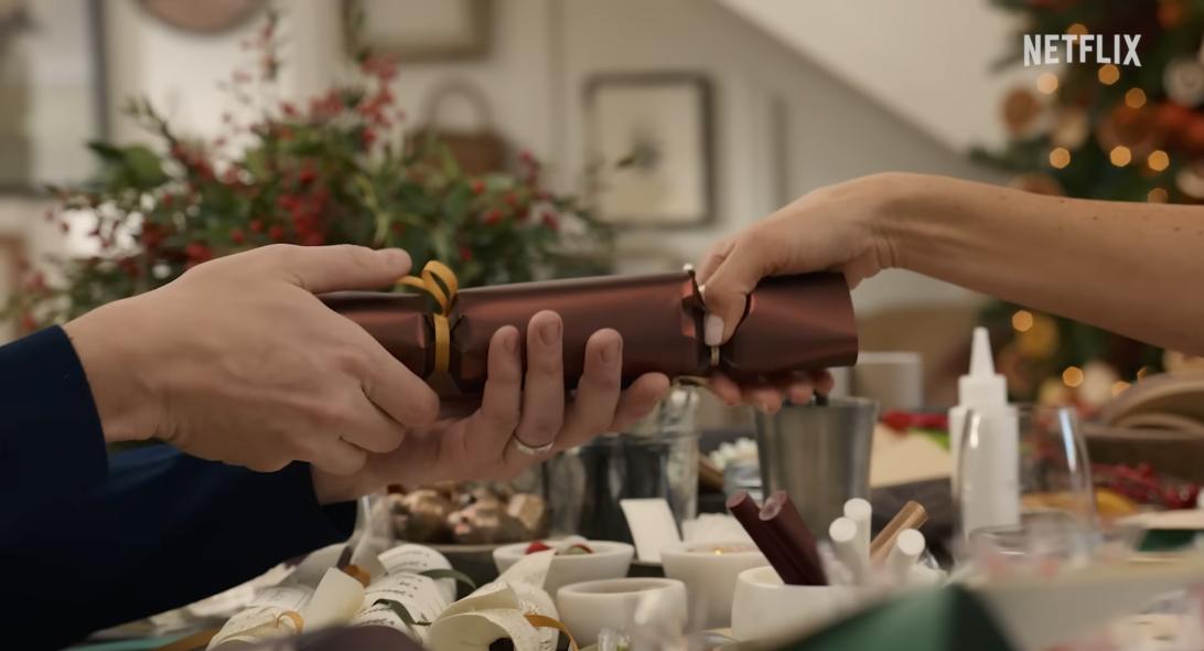 Двое разрывают рождественский крекер.