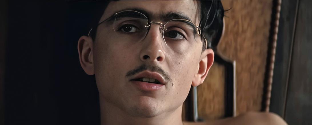 Портрет Тимоти Шаламе в очках и с усами.