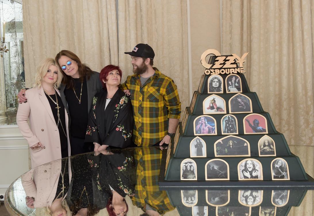 Келли, Оззи, Шэрон и Джек Осборны позируют у пирамидальной инсталляции «Оззи Осборн».
