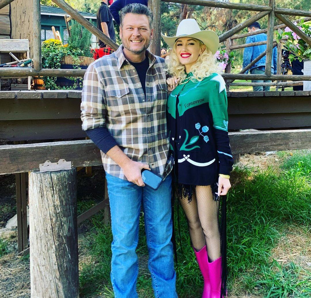 Блейк Шелтон и Гвен Стефани позируют вместе, Гвен — в эффектной ковбойской шляпе и розовых сапогах.