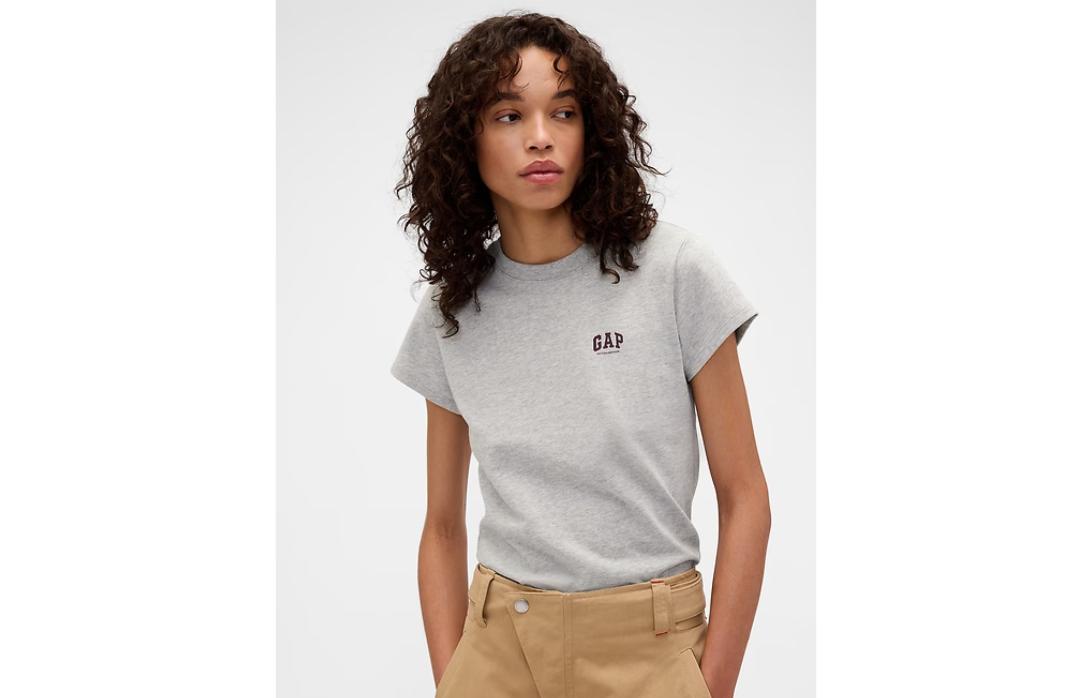 Женщина с темными кудрями в серой футболке GAP и брюках цвета хаки.
