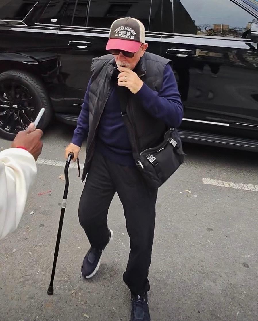 Билли Джоэл неузнаваем в шляпе, очках, жилетке и с тростью.