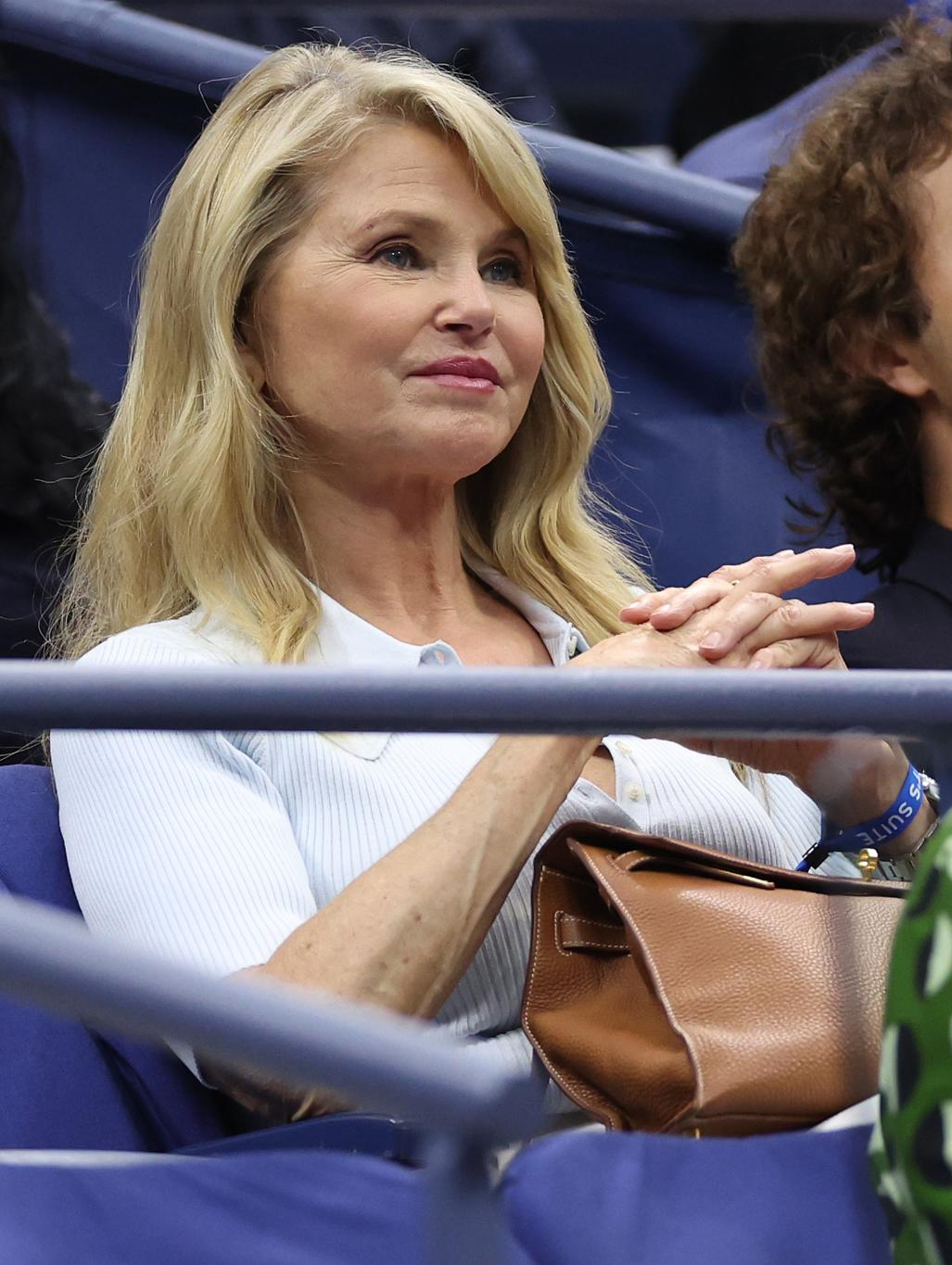 Американская модель Кристи Бринкли наблюдает за мужчинами.