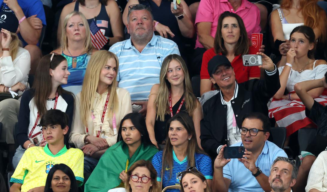 Кит и Николь с дочерьми, Фейт и Сандей, наблюдали за выступлением гимнасток.