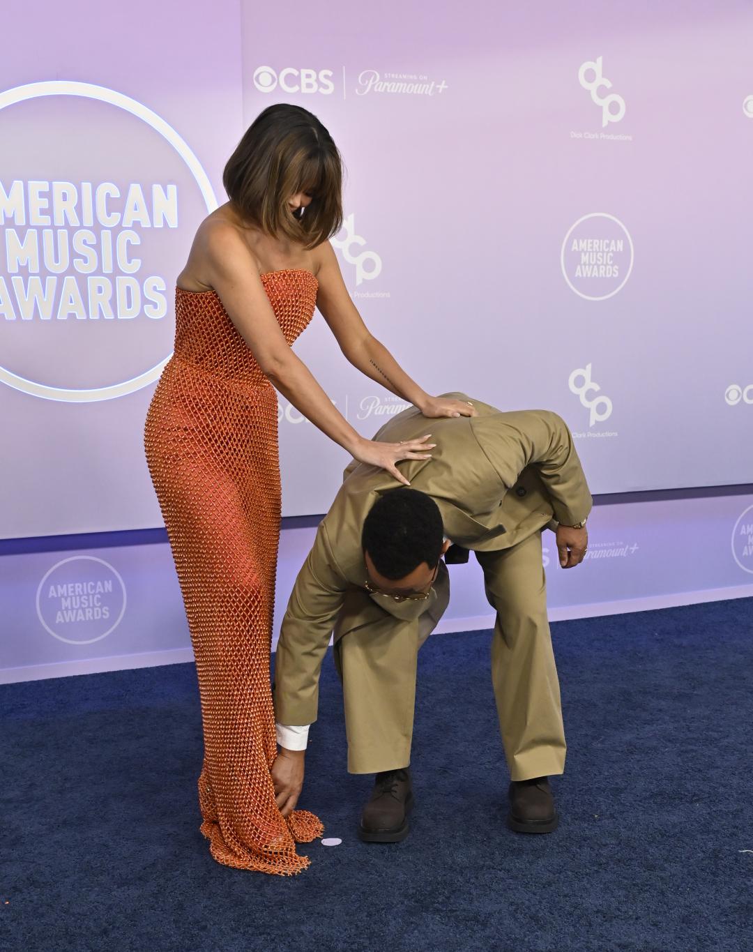 Крисси Тиген в оранжевом платье и Джон Ледженд в бежевом костюме на American Music Awards.