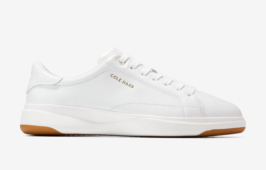 Белые кожаные кроссовки Cole Haan с белыми шнурками и коричневой подошвой.